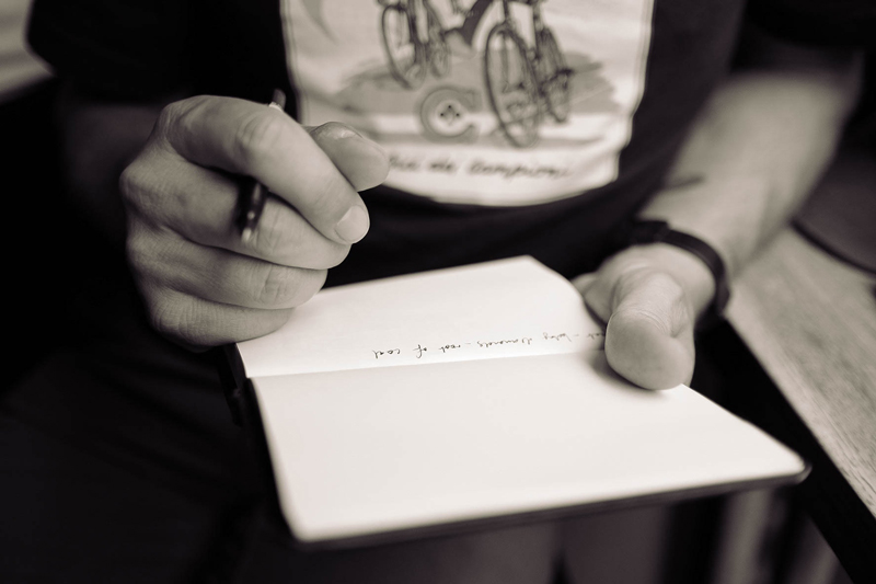 Close up of a man’s hands holding a pen and notebook. Credit - Photo by Calum MacAulay on Unsplash